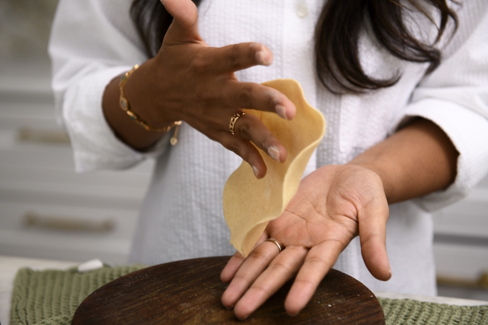 Palak Patel, who runs the cooking blog the Chutney Life, tosses roti dough at home in Newtown. — NYT