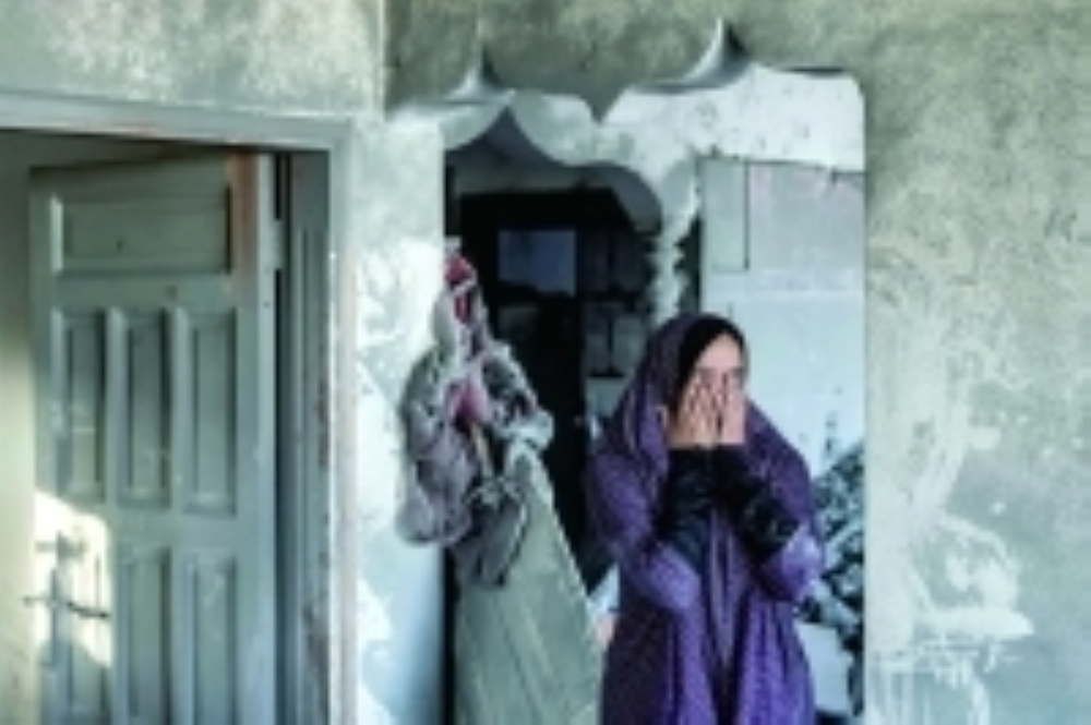 A woman reacts as she stands in a heavily damaged house following Israeli bombardment in Rafah in the southern of Gaza Strip. - AFP
