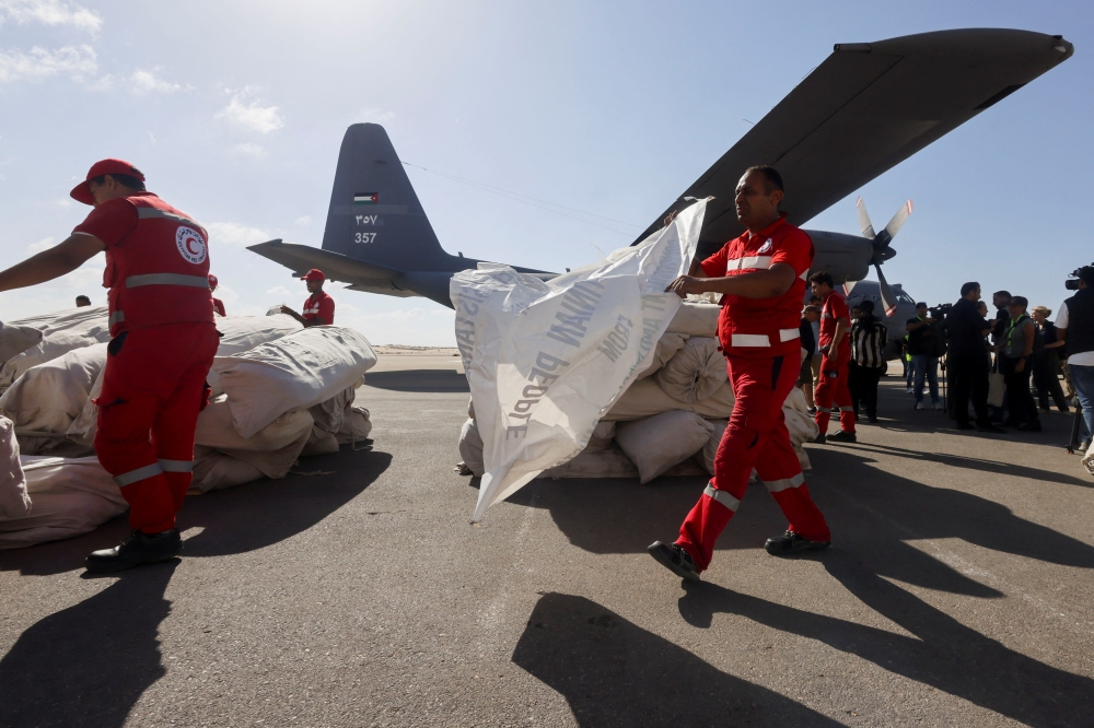 Egyptian Red Crescent members coordinate aid for Gaza, as United Nations Secretary-General Antonio Guterres speaks to the media, after visiting the Rafah border crossing between Egypt and the Gaza Strip, at Al Arish Airport, Egypt, October 20, 2023. REUTERS/Amr Abdallah Dalsh
