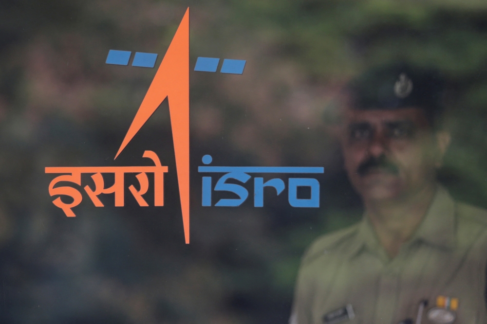  A security guard stands behind the logo of Indian Space Research Organisation (ISRO) at its headquarters in Bengaluru, India, June 12, 2019. 