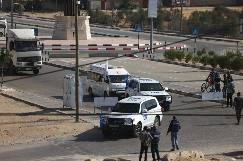 United Nations vehicles and empty lorries wait on the Palestinian side of the Gaza border at Rafah to collect humanitarian aid 