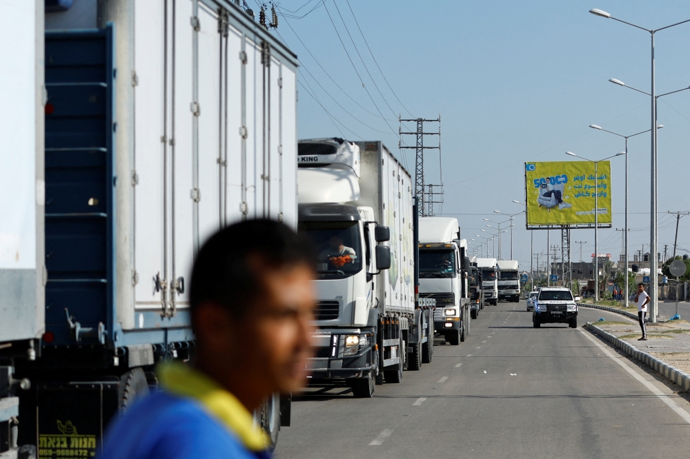 Trucks head to the Egyptian side of the border to be loaded with aid that will be delivered to Palestinians in Gaza