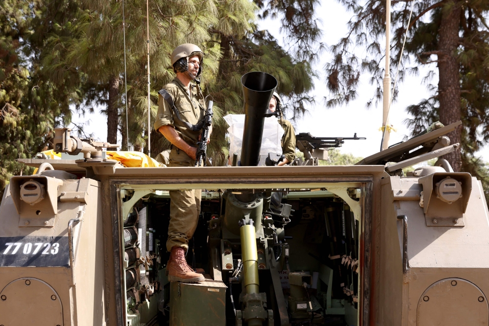 An Israeli soldier stand in an armoured vehicle stationed at an undisclosed area in northern Israel near the Lebanon border. — AFP 