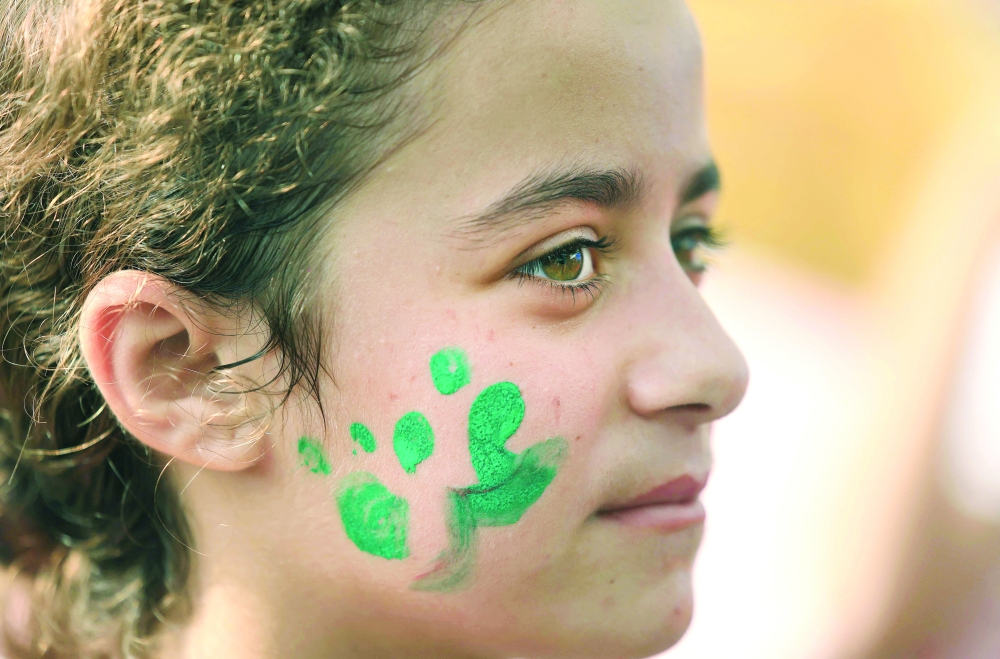 A Palestinian child shows her painted cheek with the word 'Gaza', at a UN-run shelter in Khan Yunis in the southern Gaza Strip, on Monday. - AFP