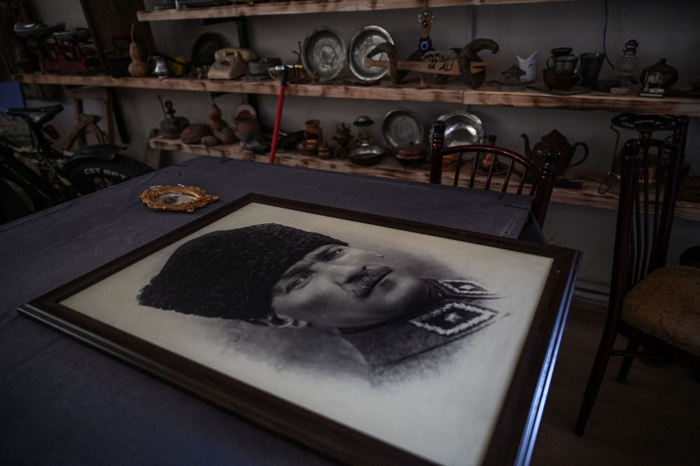 A portrait of founder of modern Turkey Mustafa Kemal Ataturk lies on a desk in a cafe in Kemaliye, eastern Turkey on October 4, 2023. Founder of modern Turkey Mustafa Kemal Ataturk rewarded the loyalty of the Kemaliye town, nestled between the mountains and the sources of the Euphrates, by giving it his name ahead of creating the Turkish republic out of the ashes of the Ottoman Empire 100 years ago. (Photo by Ozan KOSE / AFP)

