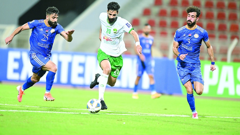 Al Nahda's Omar al Malki moves past Al Futuwa players. -- Abdulwahid al Hamadani