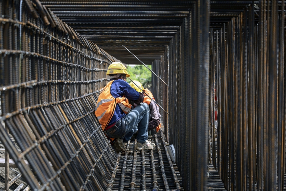 Labourers work at the construction site of an elevated highway on the outskirts of Shanghai. — Reuters