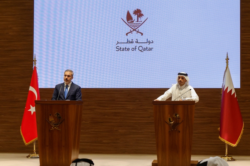 Qatar's Prime Minister and Foreign Minister Mohammed bin Abdulrahman al-Thani (R) and Turkey's Foreign Minister Hakan Fidan hold a press conference in Doha on October 25, 2023. (Photo by KARIM JAAFAR / AFP)


