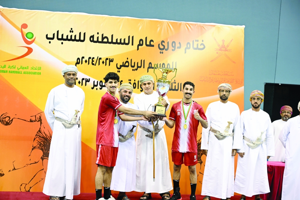 Muscat players receive the winner's trophy. -- Khalfan al Ruzaiqi