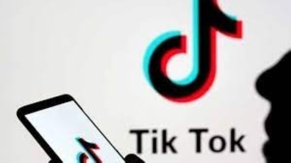 A person holds a smartphone as Tik Tok logo is displayed behind in this picture illustration. — Reuters