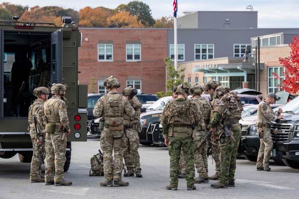 Law enforcement officers gather outside Lewiston High School, Maine. - AFP 