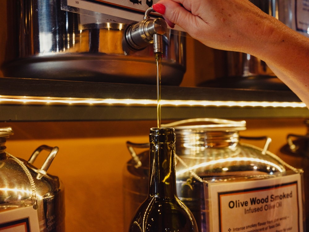 Olive oil is poured into a bottle at Infused Oils & Vinegars in Dallas on Tuesday, Oct. 10, 2023. (Zerb Mellish/The New York Times)