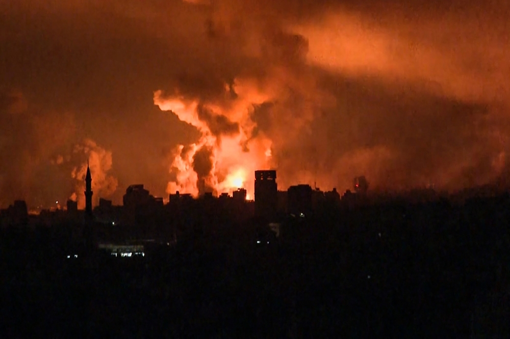 This image grab from an AFP TV footage shows balls of fire rising above Gaza City during an Israeli strike on October 27, 2023, as battles between Israel and the Palestinian Hamas movement continue.  (Photo by AFP)


