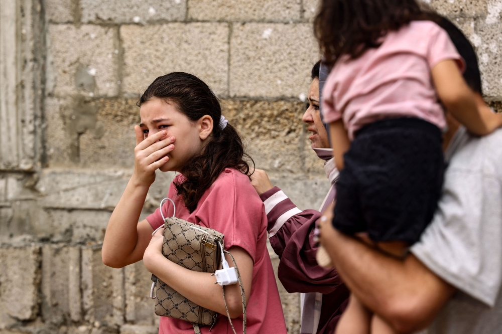 A child and a woman react in the aftermath of Israeli bombing in Rafah in the southern Gaza Strip