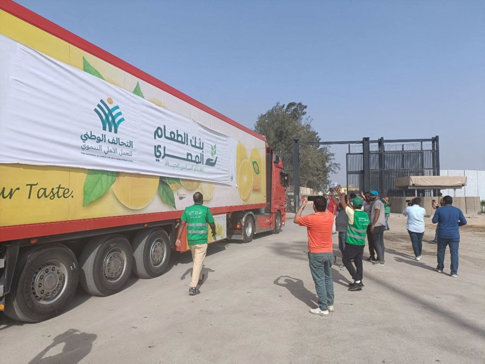 Egyptian volunteers gather next to a truck carrying humanitarian aid