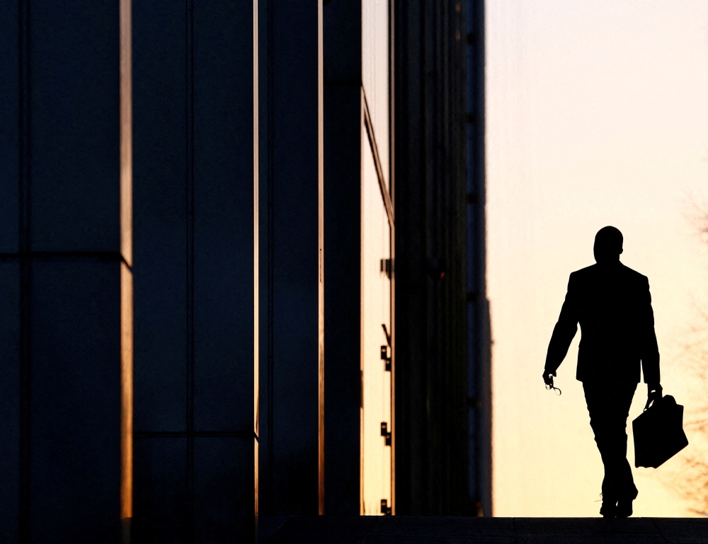 A worker arrives at his office in the Canary Wharf business district in London. — Reuters