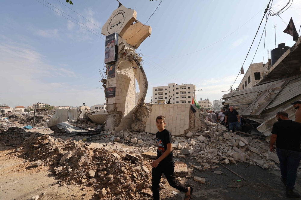 Palestinians survey the destruction following an Israeli military raid on the Jenin Palestinian refugee camp, in Jenin, northern the West Bank. — AFP
