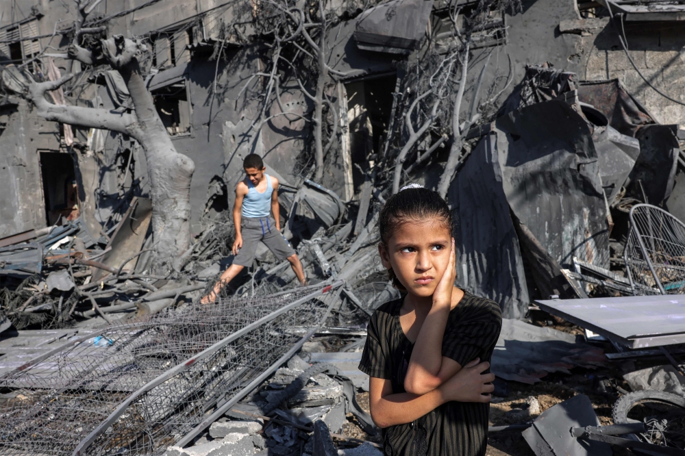 A girl looks on as she stands by the rubble outside a building that was hit by Israeli bombardment in Rafah. — AFP 
