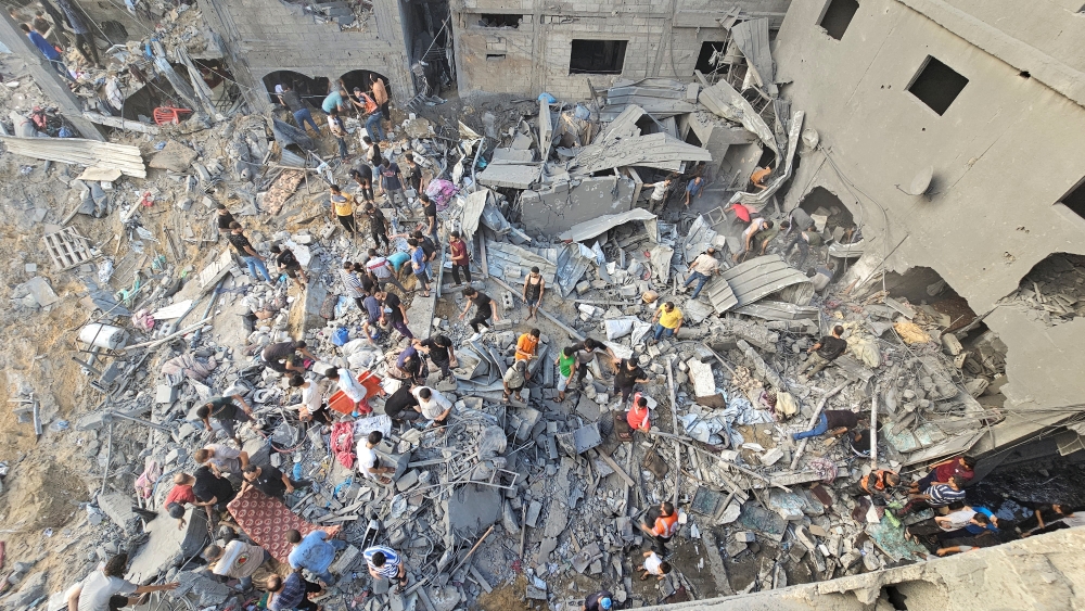 Palestinians search for casualties at the site of Israeli strikes on houses in Jabalia refugee camp in the northern Gaza Strip