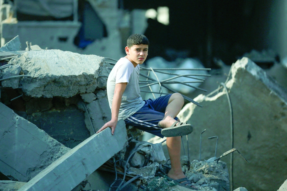 A Palestinian boy sits amidst destruction in the aftermath of an Israeli strike in the Jabalia camp for Palestinian refugees in the Gaza Strip, on Wednesday. — AFP