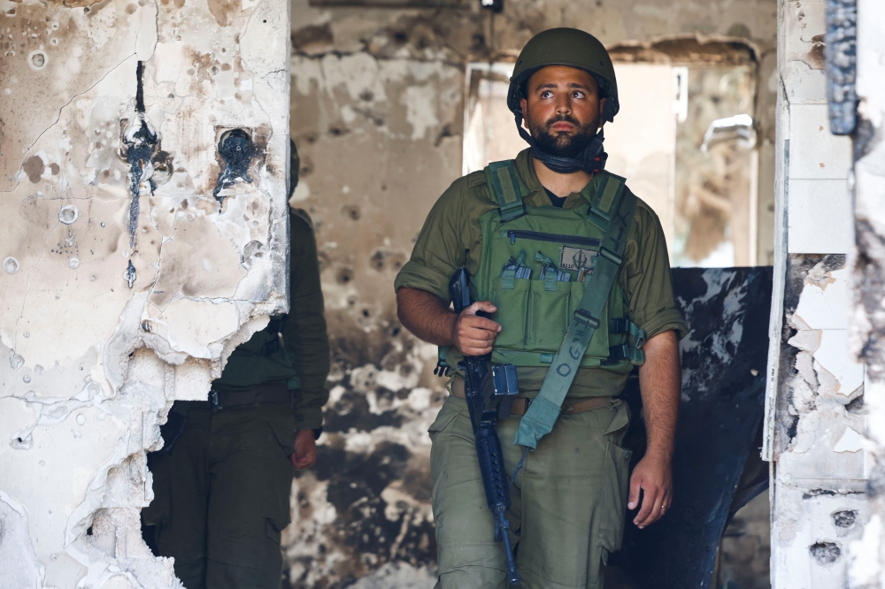 A soldier looks on in a destroyed home riddled with bullets, following the deadly October 7 attack by Hamas gunmen from the Gaza Strip, in Kibbutz Kfar Aza, southern Israel November 2, 2023.