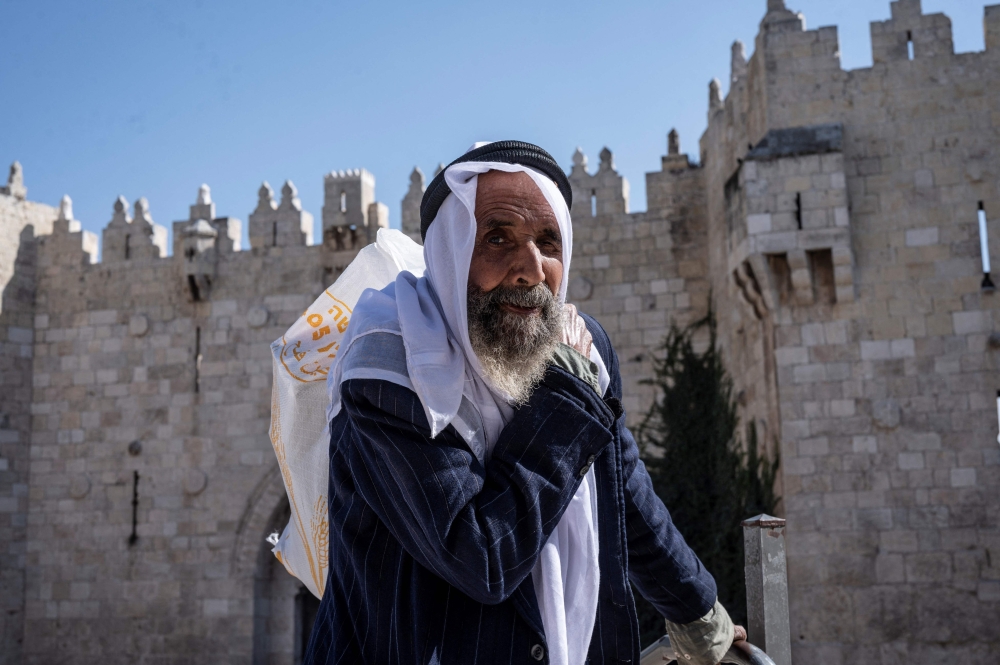 A Palestinian walks past the Damascus Gate, as worshippers leave the Old City of Jerusalem following Friday Noon prayers. - AFP

