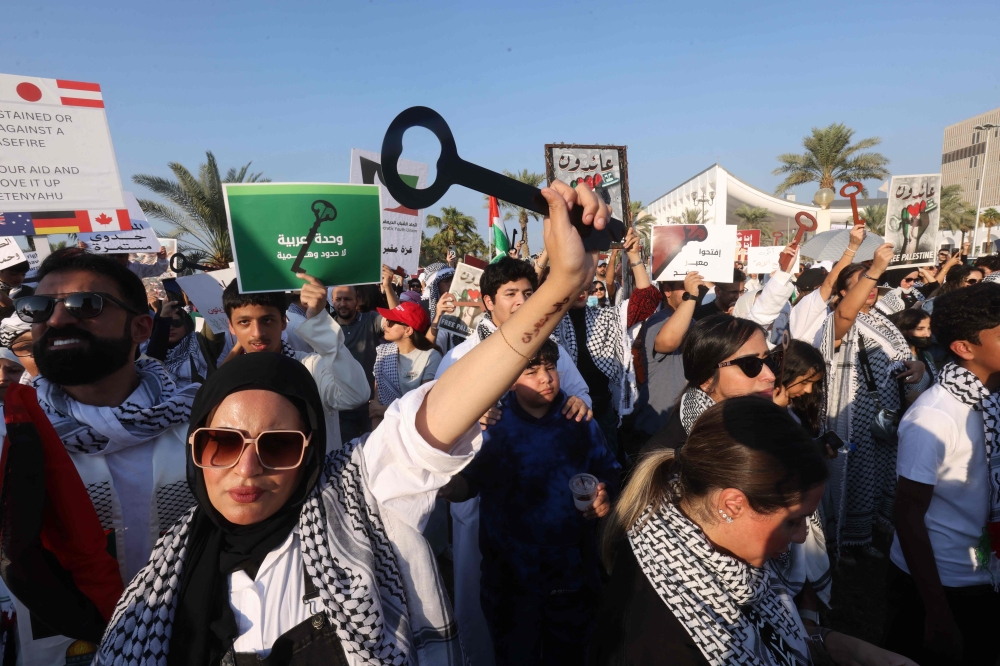 Kuwaitis hold up the keys representing homes abandoned by Palestinians as they fled their homes in Palestine in 1948, during a rally in solidarity with the Palestinian people during a rally in Iradah Square in Kuwait City. - AFP