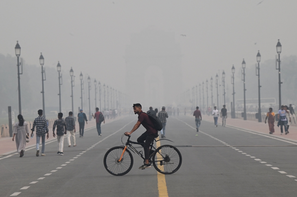 People near India Gate amid heavy smog conditions in New Delhi on Friday. — AFP
