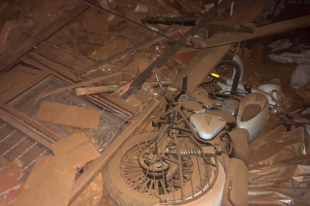A motorcycle and broken windows are seen in the midst of the rubble in the aftermath of an earthquake in Jajarkot