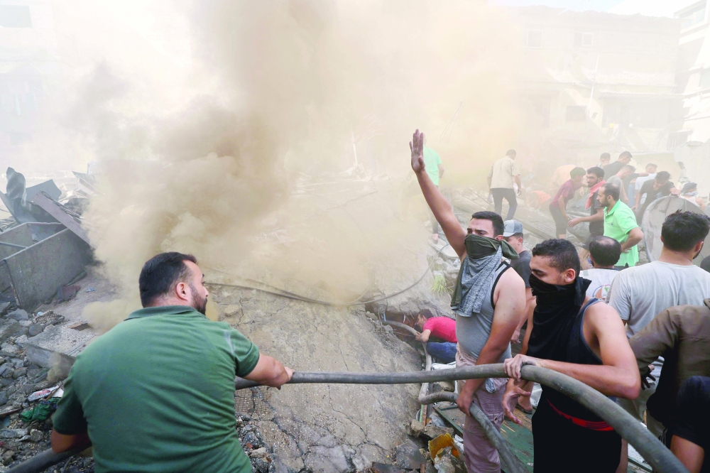 Palestinians sift through the rubble of a building in Khan Yunis. — AFP 