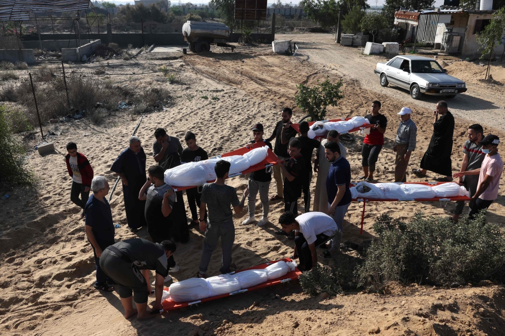 Talaat Barhom (L) attends the funeral of his wife and four of his children killed in Israeli bombardment, in Rafah 