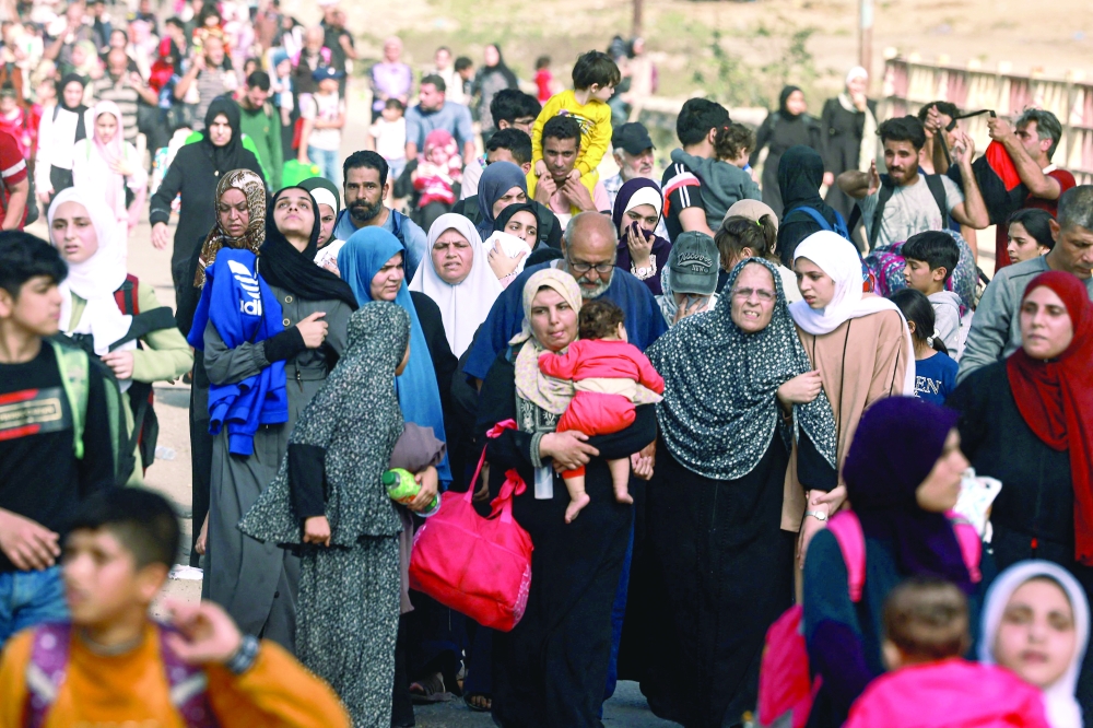 Palestinians fleeing Gaza City towards the southern areas walk on a road amid the ongoing battles. — AFP