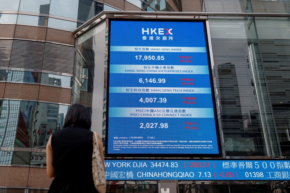A screen showing the Hang Seng stock index is seen outside Exchange Square, in Hong Kong.__Reuters
