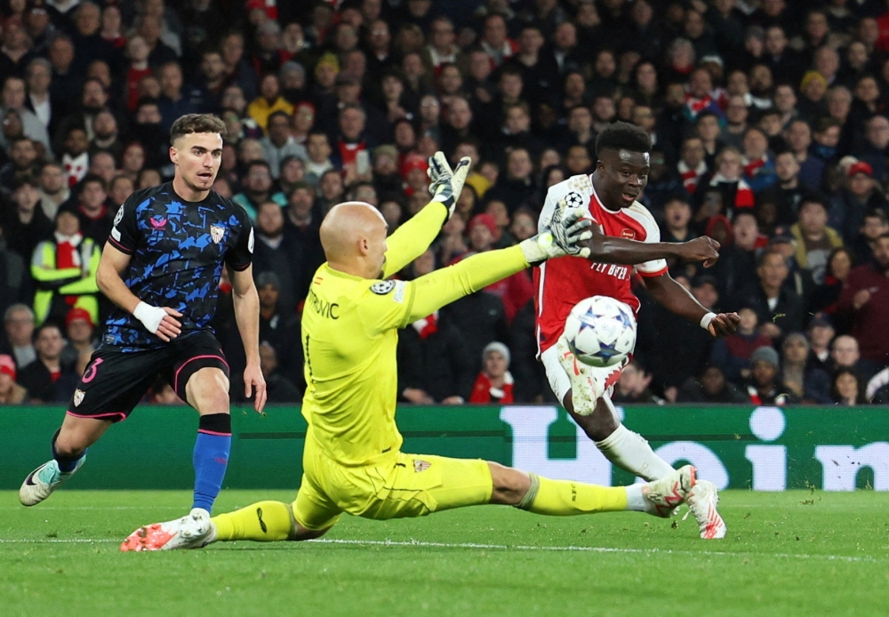 Arsenal's Bukayo Saka scores their second goal past Sevilla's Marko Dmitrovic during the Champions League - Group B match at Emirates Stadium in London. -- Reuters