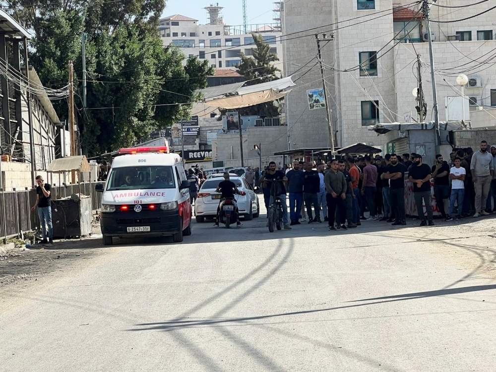 Palestinians wait in front of a hospital during an Israeli raid in Jenin 
