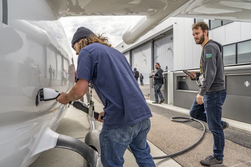 A Beta Technologies employee plugging in the experimental Alia CTOL electric aircraft for charging in Burlington. 