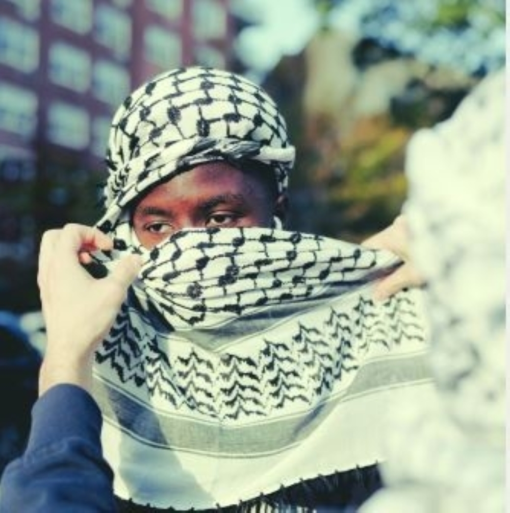 An attendee wearing a kaffiyeh around their face at a protest in Brooklyn to support Palestinians in Gaza.

