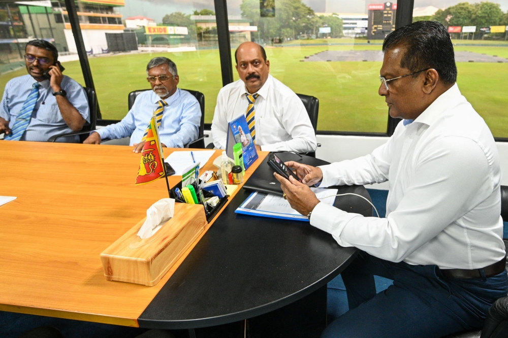 President of Sri Lanka's cricket board Shammi Silva (R) checks his phone at the Sri Lanka cricket board office in Colombo on November 7, 2023. Sri Lanka's Court of Appeal quashed the sports minister's decision to sack the country's crisis-ridden cricket board and restored the expelled officials on November 7 pending a full hearing. (Photo by Ishara S. KODIKARA / AFP)