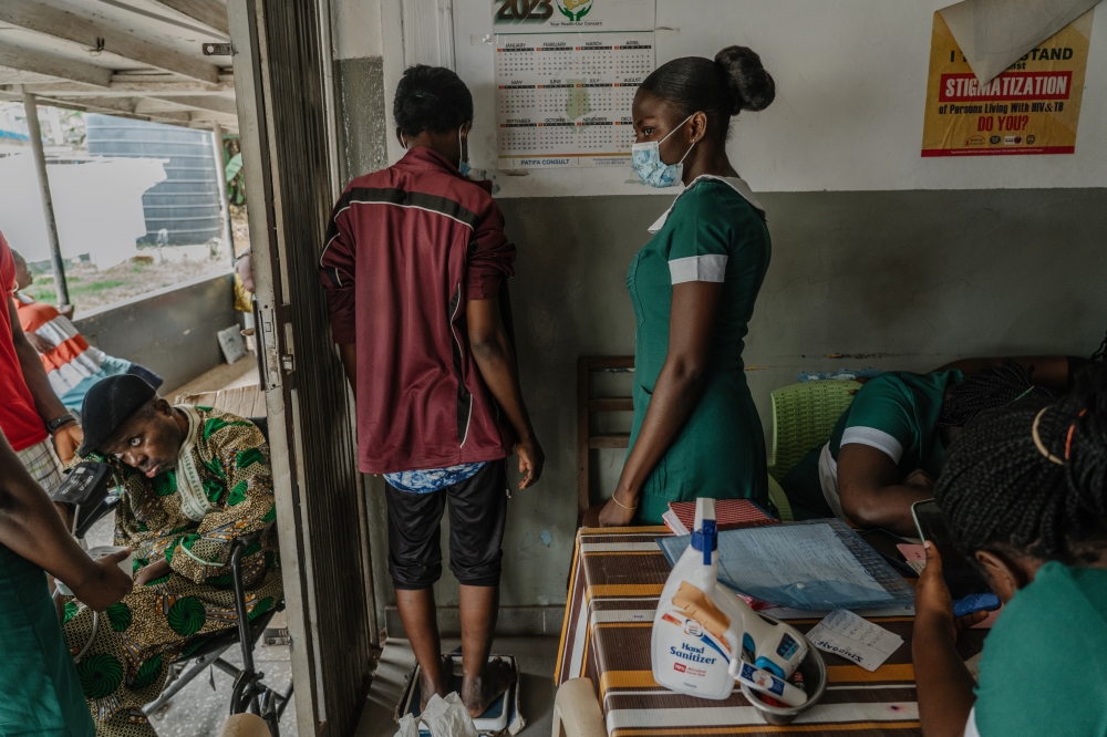 Gifty Gyan (left) who was diagnosed with tuberculosis in June, is weighed at the Kaneshie Polyclinic in Accra, Ghana, Oct. 24, 2023. (Natalija Gormalova/The New York Times)