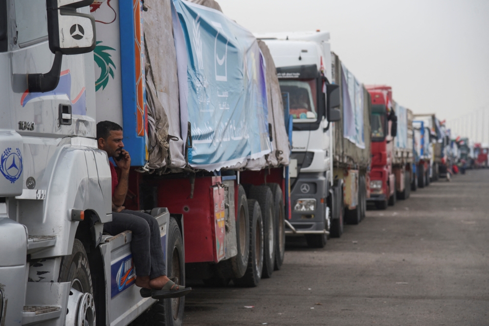 Trucks carrying humanitarian aid, wait on the desert road (Cairo - Ismailia) on their way to the Rafah border crossing to enter Gaza. — Reuters 