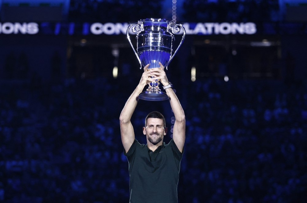 Tennis - ATP Finals - Pala Alpitour, Turin, Italy - November 13, 2023 Serbia's Novak Djokovic poses as he celebrates with the trophy for his 2023 world number one ranking REUTERS/Guglielmo Mangiapane
