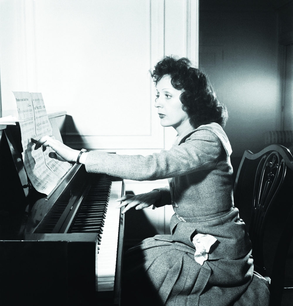 (FILES) French singer Edith Piaf plays the song "Un monsieur me suit dans la rue" at her home in New York in September 1946. Warner Music and Piaf beneficiaries announced on November 14, 2023, the advanced developement of a 90 minute animated biopic of Edith Piaf produced via artifical intelligence "to recreate her voice and image", as 2023 marks the 60th anniversary of the death of the French singer. (Photo by Eric SCHWAB / AFP)

