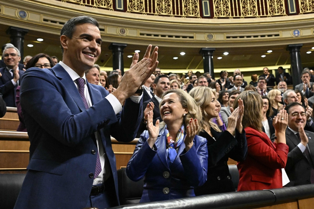 Spain's acting Prime Minister Pedro Sanchez celebrates after winning a parliamentary vote to elect Spain's next premier, at the Congress of Deputies in Madrid. - AFP