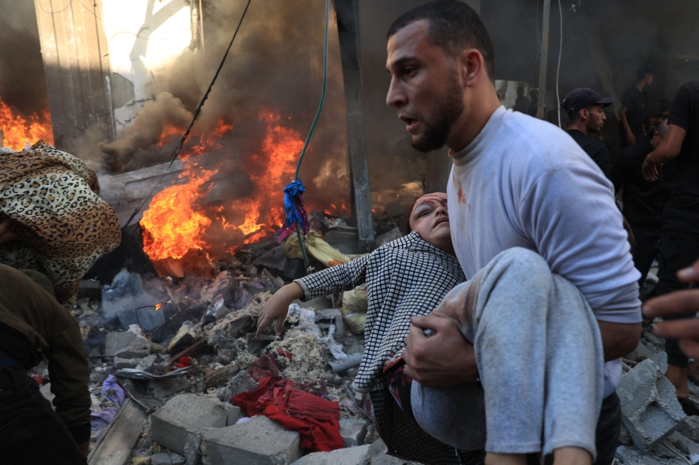 A man evacuates a wounded girl after Israeli bombardment in Rafah in the southern Gaza Strip on Friday. - AFP