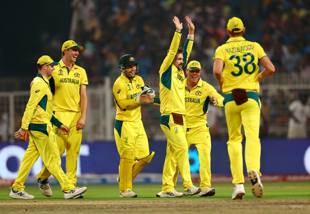 Cricket - ICC Cricket World Cup 2023 - Semi-Final - South Africa v Australia - Eden Gardens, Kolkata, India - November 16, 2023 Australia's Travis Head celebrates with teammates after taking the wicket of South Africa's Heinrich Klaasen REUTERS/Andrew Boyers
