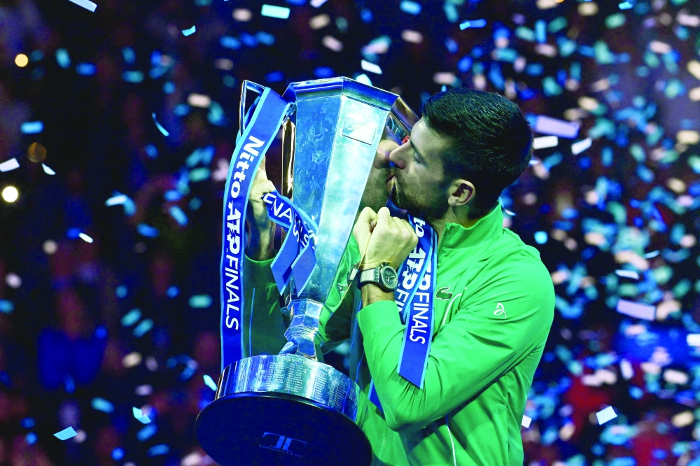 Serbia's Novak Djokovic kisses the trophy after winning the final match against Jannik.—AFP