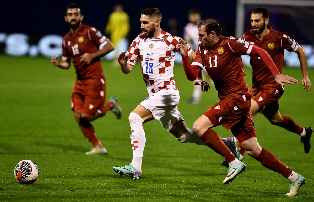 Croatia's midfielder #18 Luka Ivanusec (C) outruns Armenia's midfielder #13 Kamo Hovhannysian during the UEFA Euro 2024 Group D qualification football match between Croatia and Armenia at the Maksimir Stadium in Zagreb, on November 21, 2023.  (Photo by DENIS LOVROVIC / AFP)

