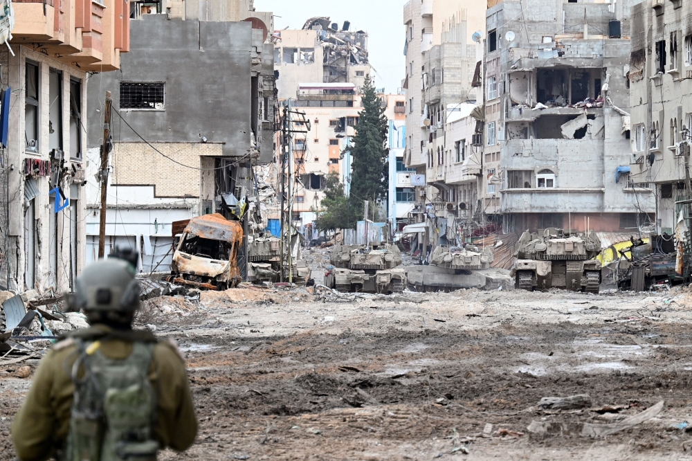  Israeli tanks roll along a street during a military operation in the northern Gaza Strip