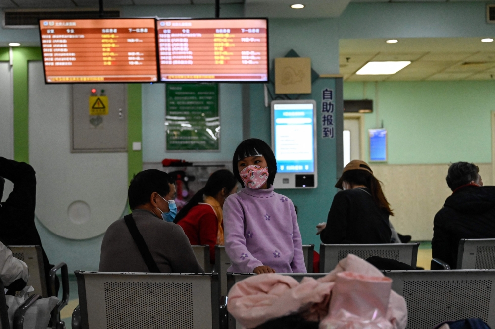 Children and their parents wait at an outpatient area at a children hospital in Beijing on Thursday. — AFP