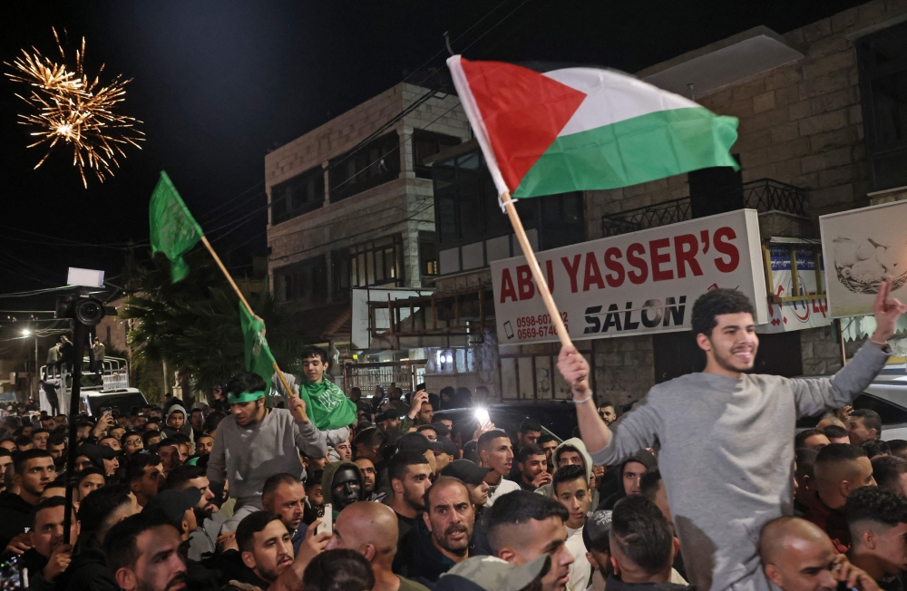 Palestinian prisoners cheer after being released from the Israeli military facility 